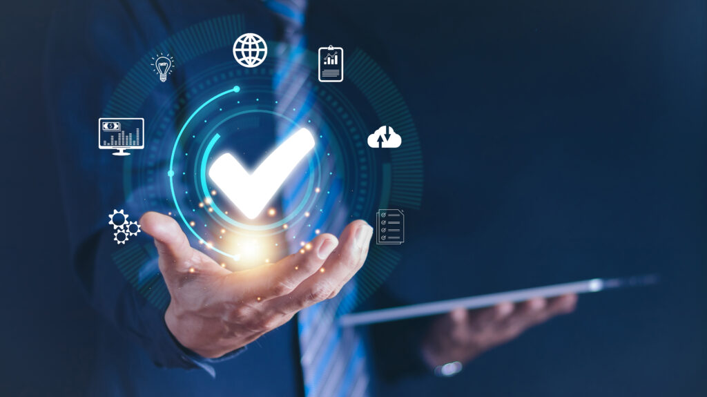 Geschäftsperson hält ein digitales Symbol mit Haken in der Hand, umgeben von Icons zu Daten und Prozessen